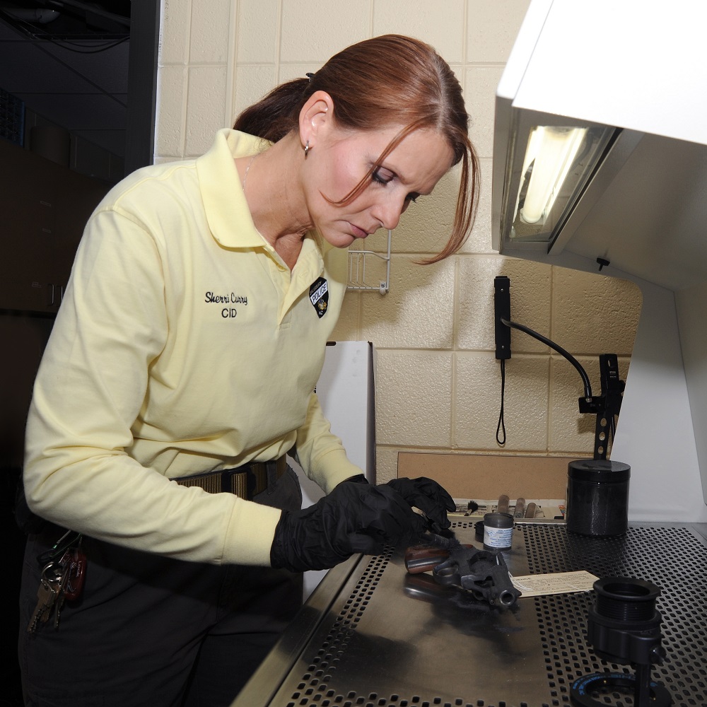 A female officer working in the crime lab