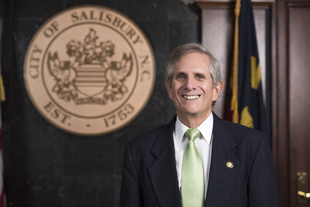 Portrait of Council member David Post in front of city seal